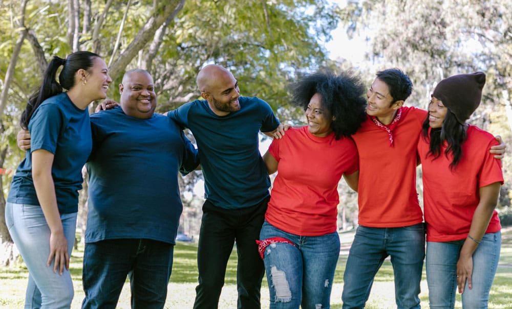 Group of friends in a park hugging and smiling